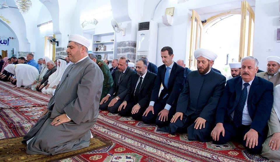 Syria’s President Bashar al-Assad (3rd R) attends prayers on the first day of Eid al-Fitr, inside a mosque in Hama