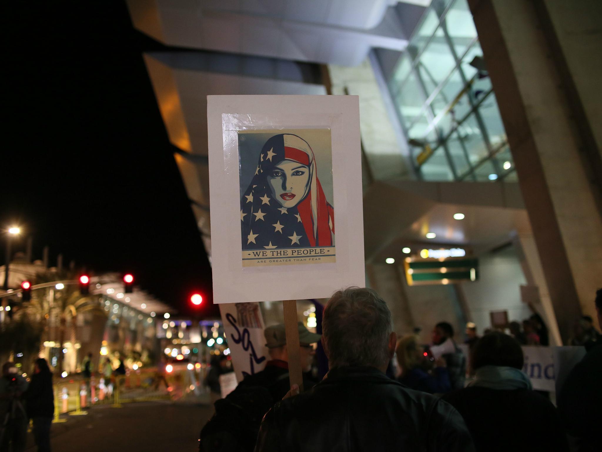 A protestor holds a sign at the airport in San Diego, California opposing Donald Trump's travel ban in January 2017