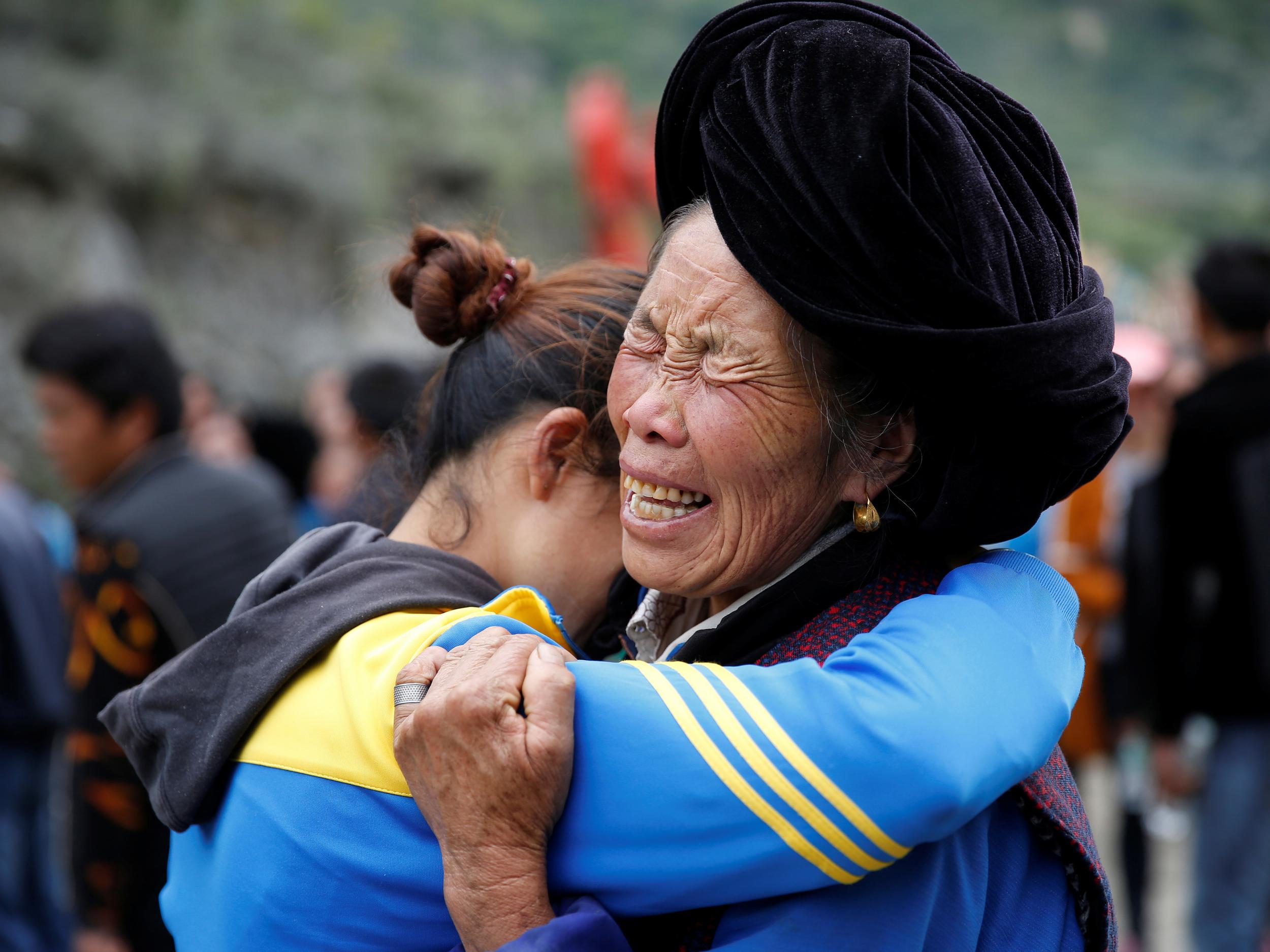 Relatives of victims react at the site of a landslide in the village of Xinmo, Mao County, Sichuan Province