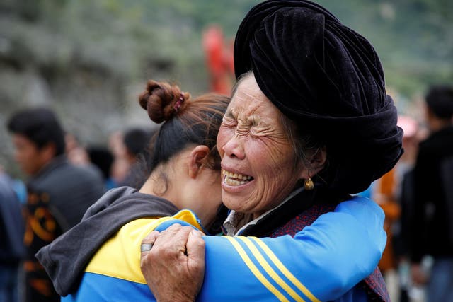 Relatives of victims react at the site of a landslide in the village of Xinmo, Mao County, Sichuan Province