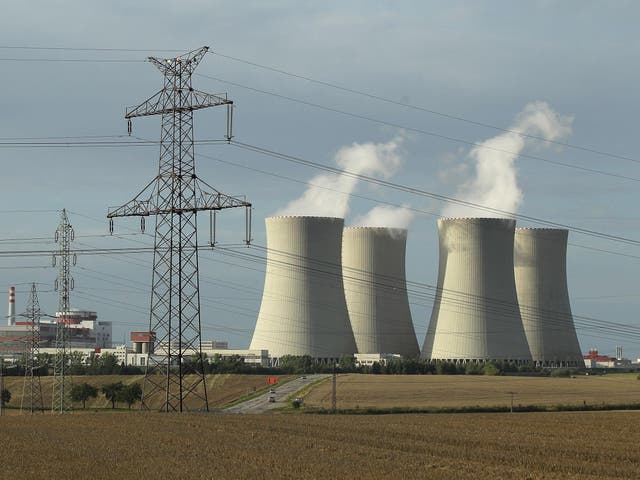An electricity pylon stands in front of the four cooling towers and two reactor blocks of the Temelin nuclear power plant in