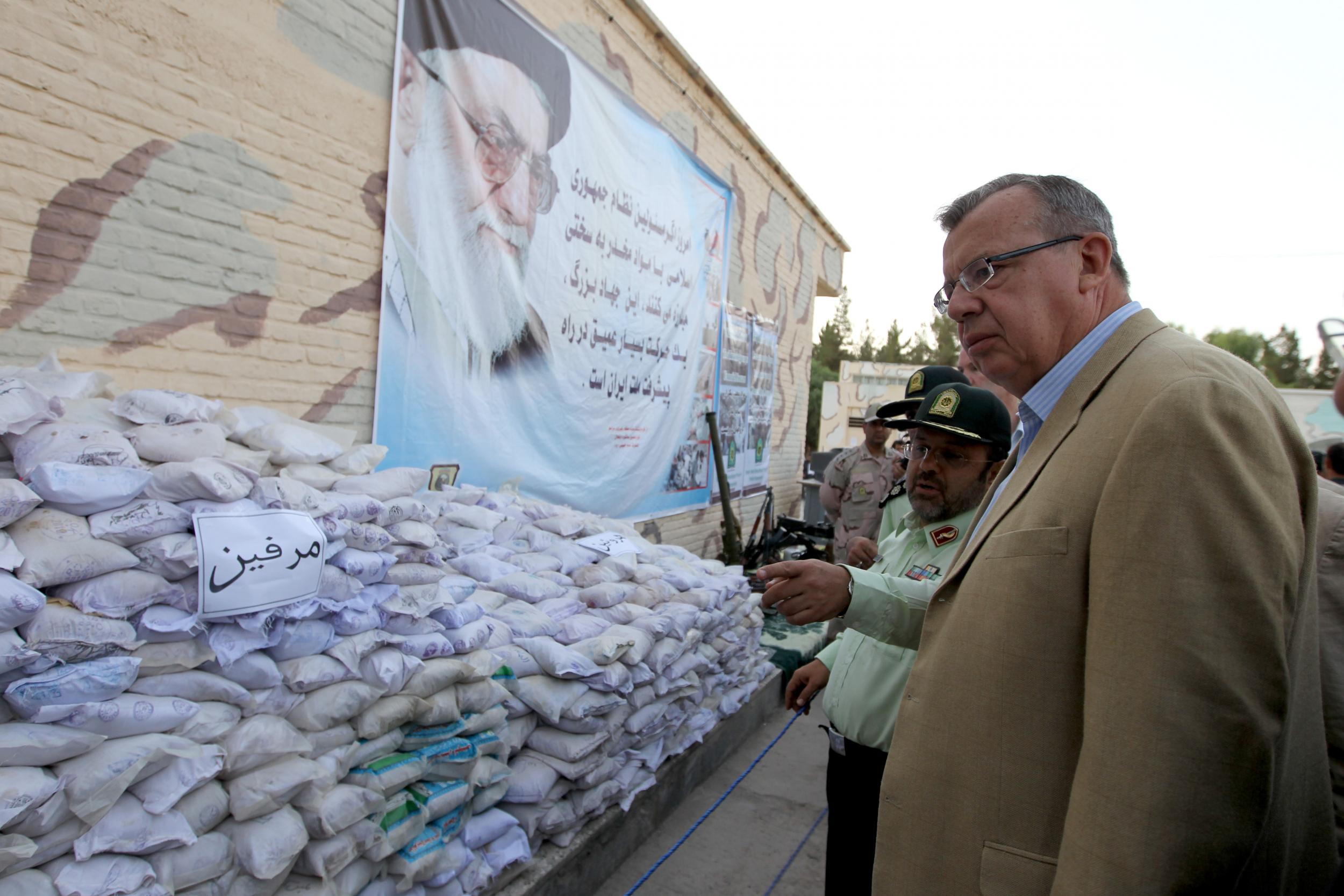 Executive director of the UN office on drugs and crime (UNODC) Yury Fedotov (R) and Iranian anti-narcotics police chief Hamidreza Housein Abadi look at bags of Afghan-made morphine on display during a media tour in the southeastern city of Zahedan, on 19 July 2011