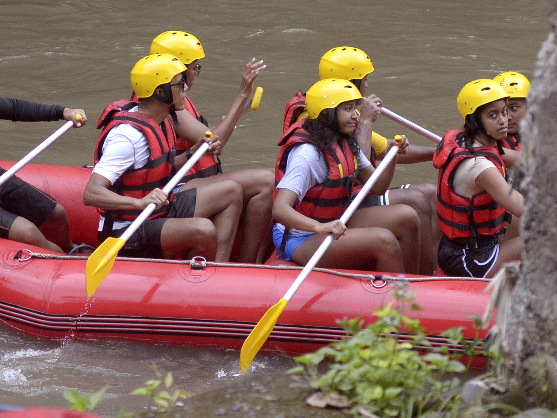 Former US President Barack Obama, his wife Michelle and daughters Malia, right, and Sasha, second right, raft on the Ayung River in Badung, Bali, Indonesia