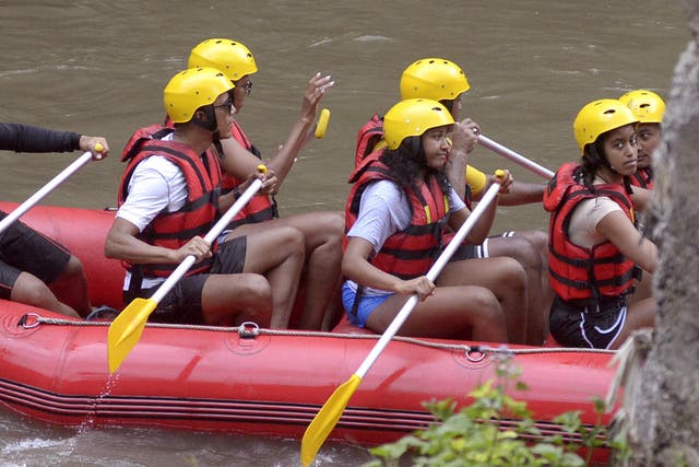 Former US President Barack Obama, his wife Michelle and daughters Malia, right, and Sasha, second right, raft on the Ayung River in Badung, Bali, Indonesia