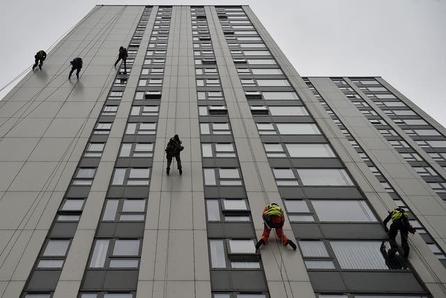 Specialists abseil down the side of Bray Tower to check the cladding on the Chalcots Estate in north London