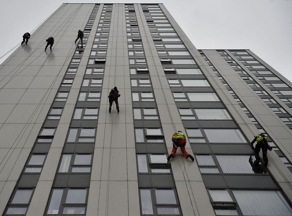 Specialists abseil down the side of Bray Tower to check the cladding on the Chalcots Estate in north London