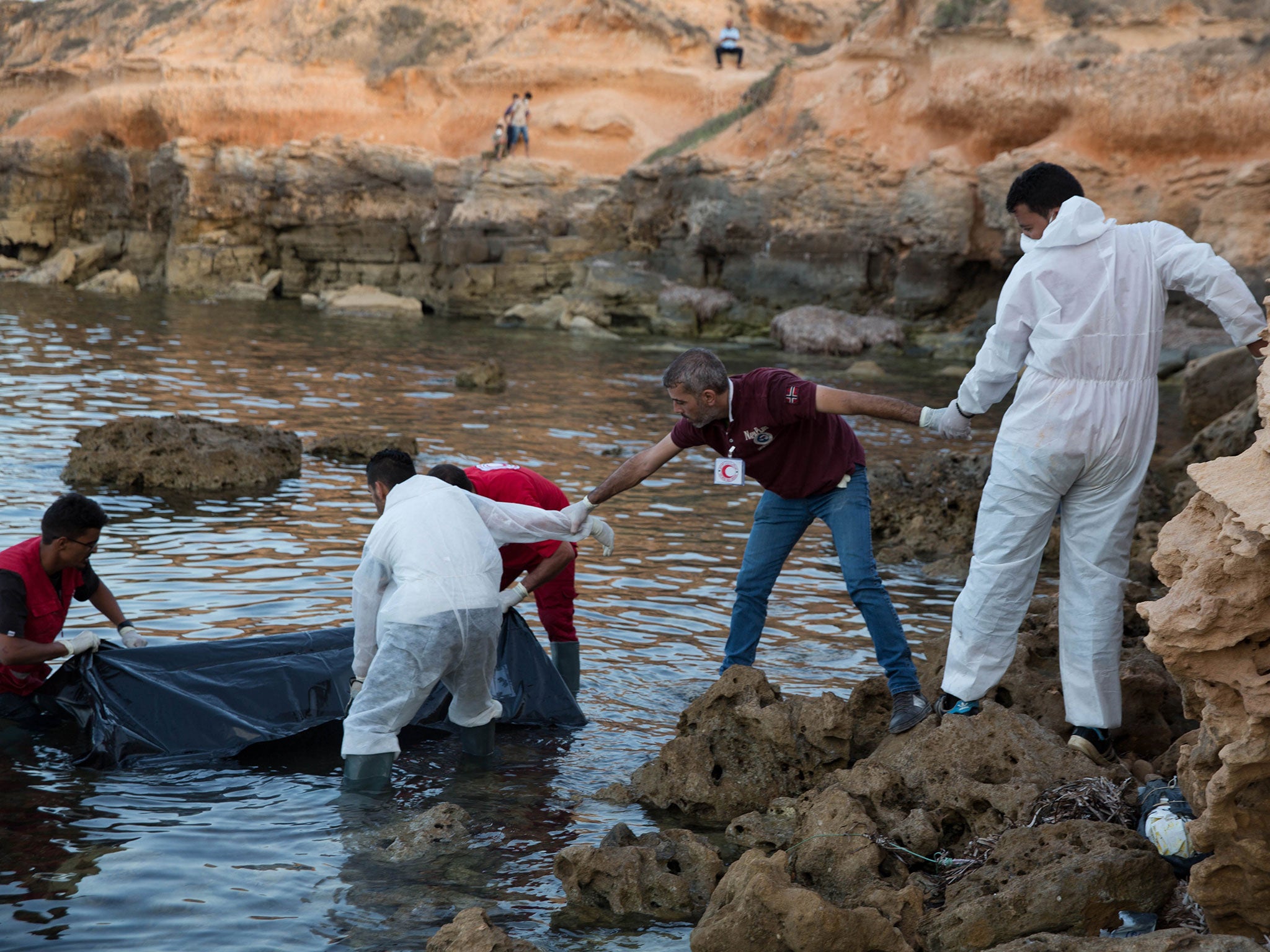 &#13;
Members of the Libyan Red Crescent recover bodies of migrants washed ashore near Tripoli, Libya, on 27 June &#13;