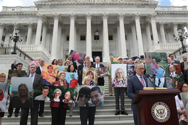 Senate Minority Leader Chuck Schumer speaks while flanked by Senate Democrats holding photos of people who would lose their health coverage under the Senate Republicans healthcare bill during a press conference at the US Capitol on 27 June 2017 