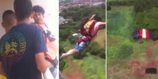 Man leaps off multi-story building wearing a parachute