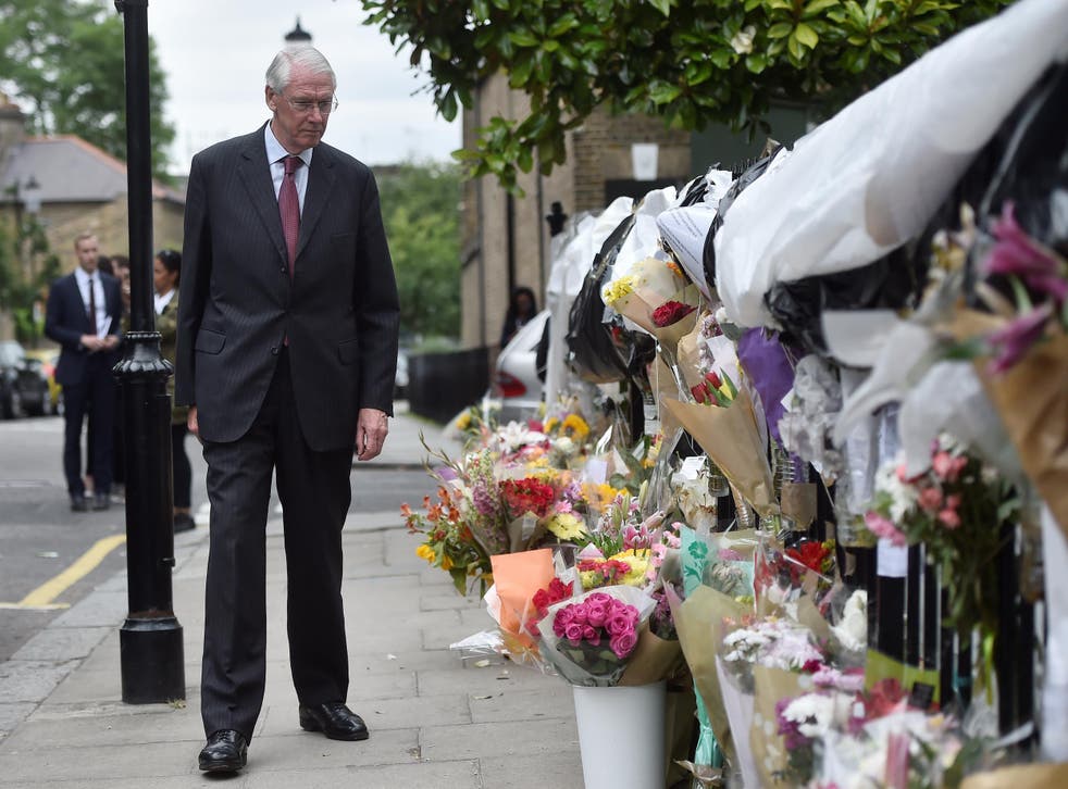 Sir Martin Moore-Bick looks at floral tributes left for the victims of the Grenfell Tower fire in North Kensington, London