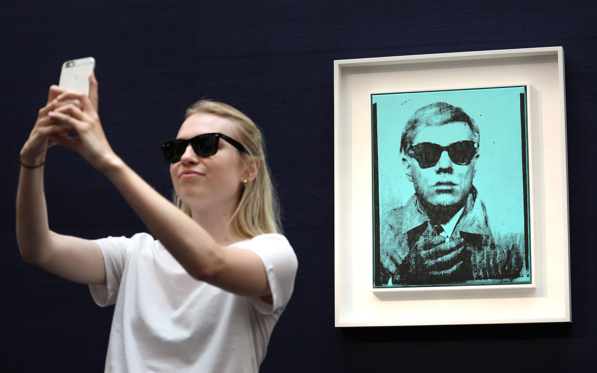Meta: A visitor takes a selfie with one of Warhol’s selfie shots