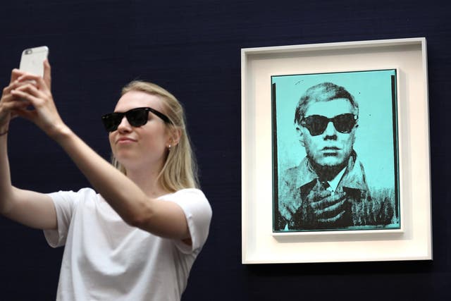 Meta: A visitor takes a selfie with one of Warhol’s selfie shots