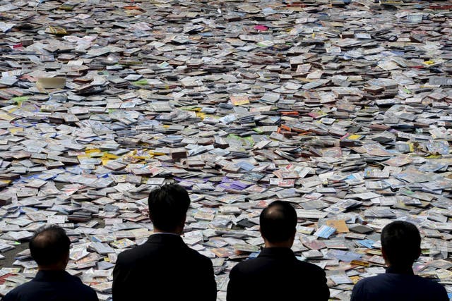 Government officials look on as pirated publications, including DVDs, CDs etc, are placed on the ground before being destroyed, during a campaign against piracy in Taiyuan, Shanxi province April 20, 2015