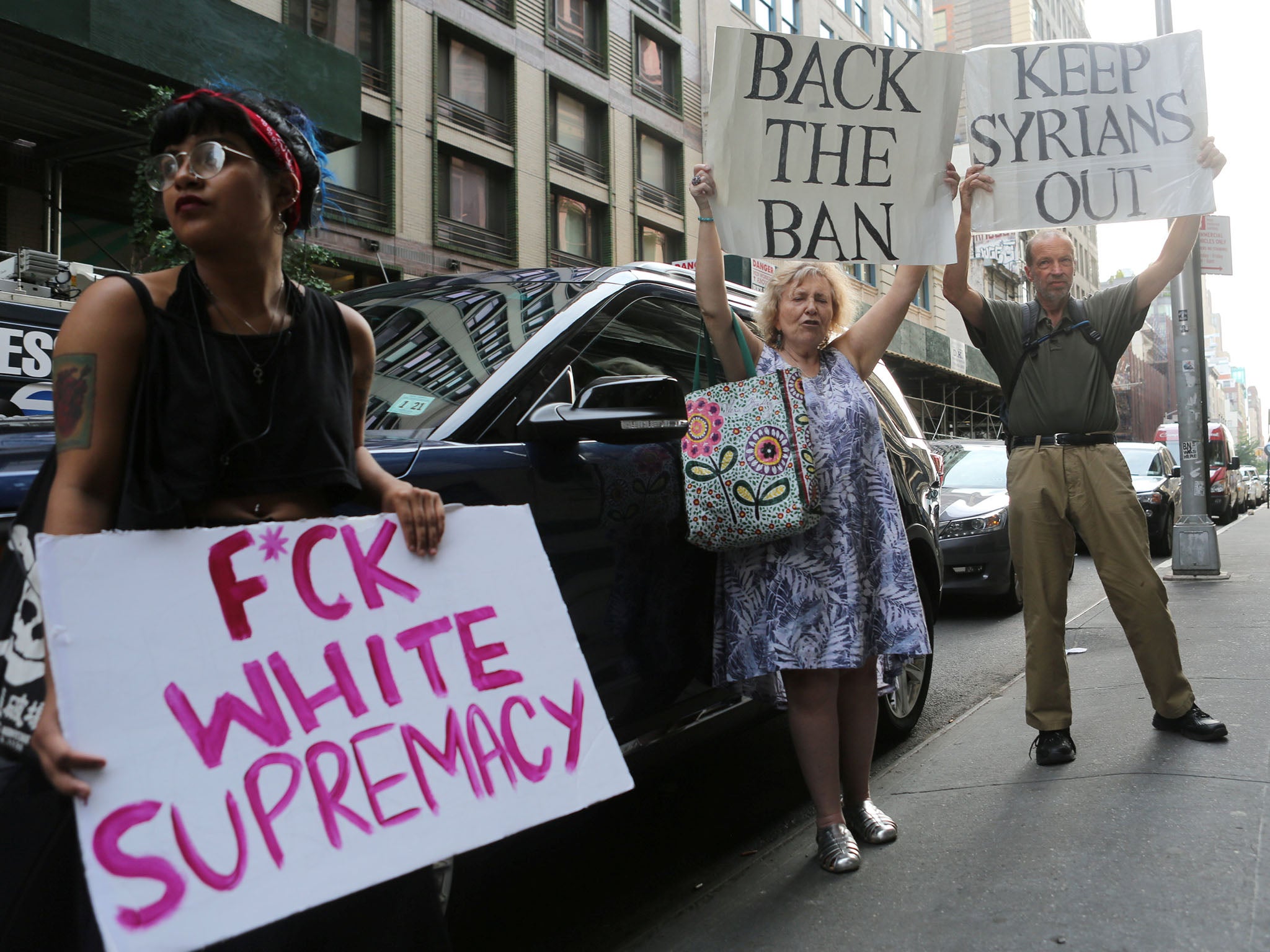 A protester against U.S. President Donald Trump's limited travel ban, approved by the U.S. Supreme Court, holds a sign next to protesters supporting the ban, in New York City, U.S., June 29, 2017