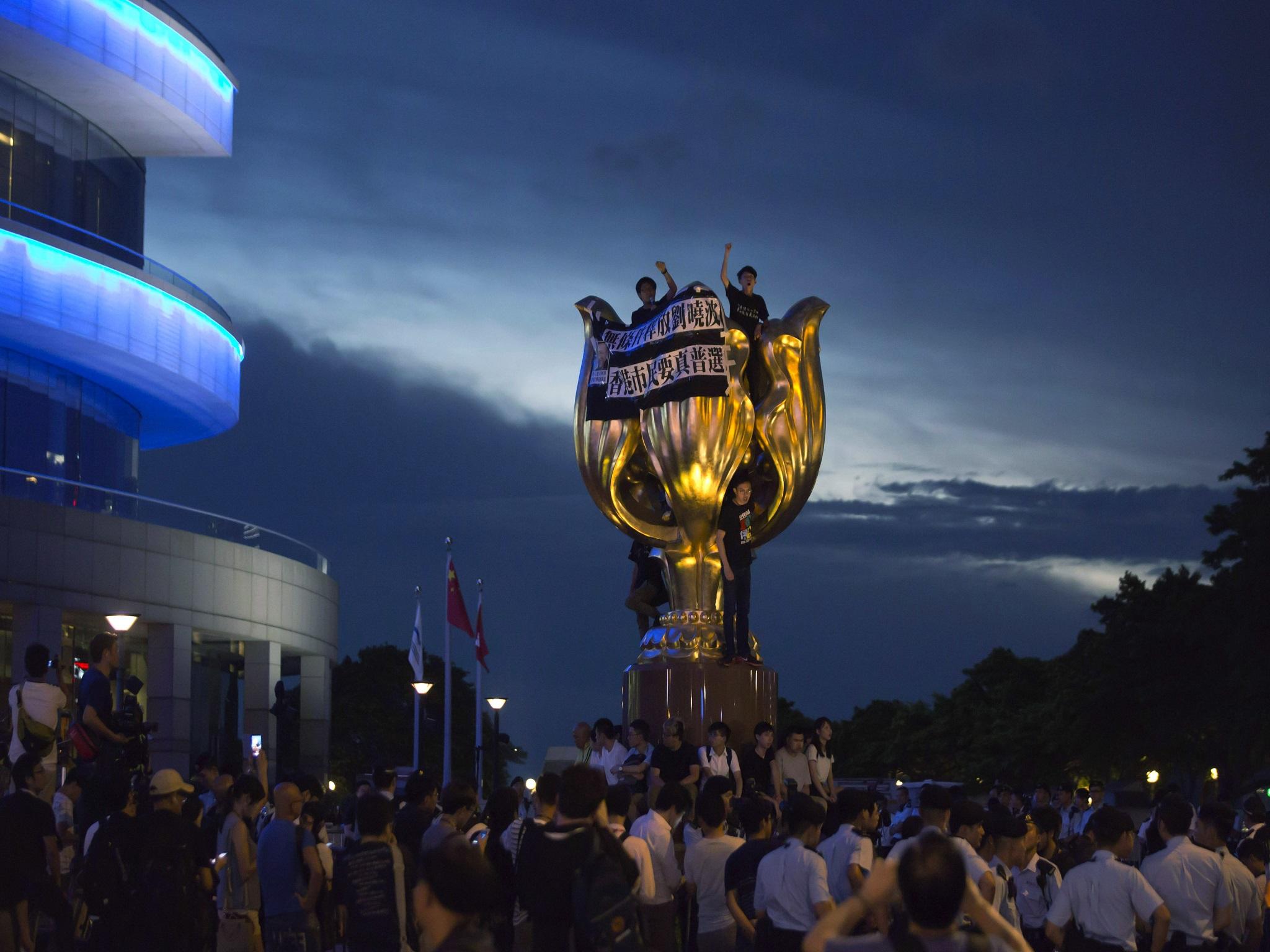 Pro-democracy activists invade the Golden Bauhinia statue in Hong Kong