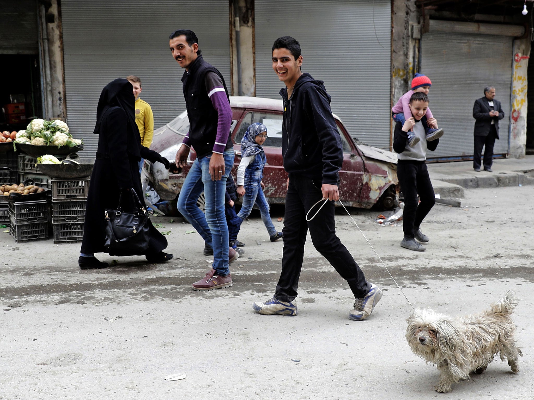 A Syrian man walks his dog in the once rebel-held al-Shaar neighbourhood of Aleppo