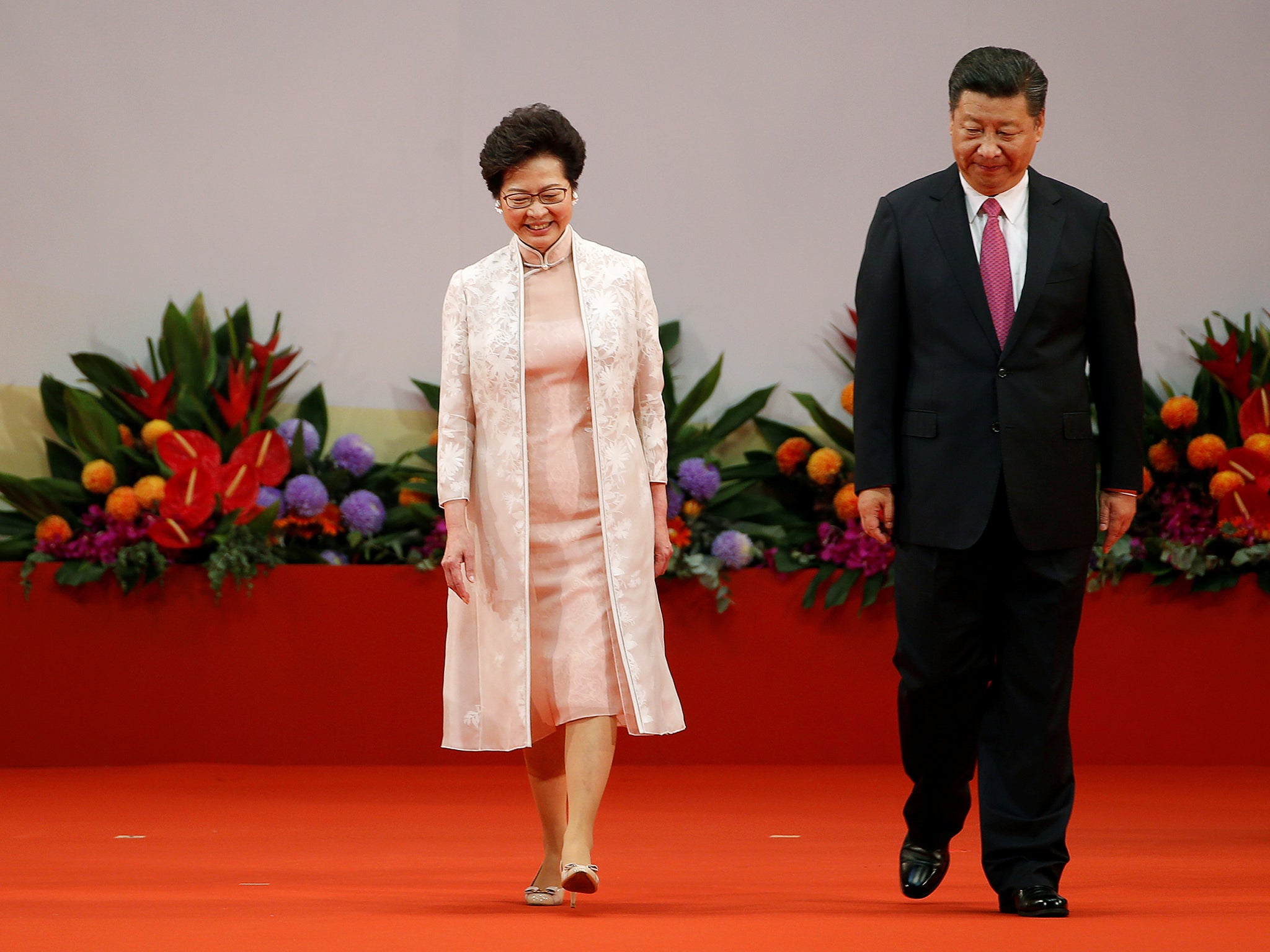 Hong Kong Chief Executive Carrie Lam (L) and Chinese President Xi Jinping walk on the podium during the 20th anniversary of Hong Kong's handover from British to Chinese rule