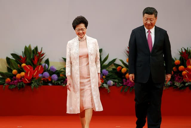 Hong Kong Chief Executive Carrie Lam (L) and Chinese President Xi Jinping walk on the podium during the 20th anniversary of Hong Kong's handover from British to Chinese rule