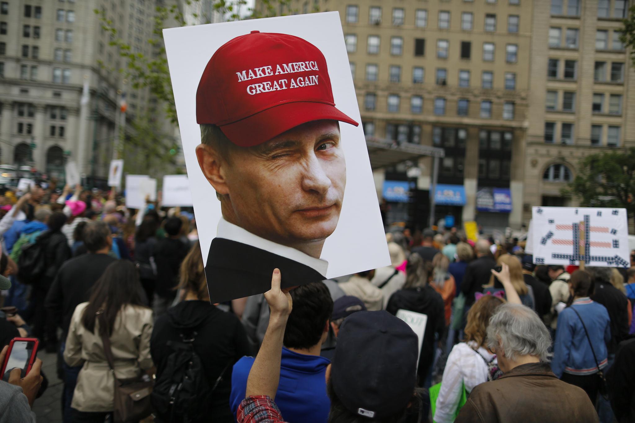 A demonstrator holds up a sign of Vladimir Putin during an anti-Trump 'March for Truth' rally on June 3, 2017 in New York City