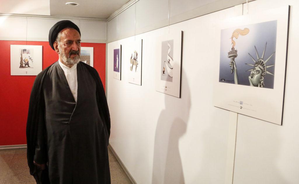 Iranian reformist cleric Mahmoud Doaei looks at cartoons of US President Donald J. Trump at an exhibition of the Islamic Republic's 2017 International Trumpism cartoon and caricature contest, in the capital Tehran on July 3, 2017.