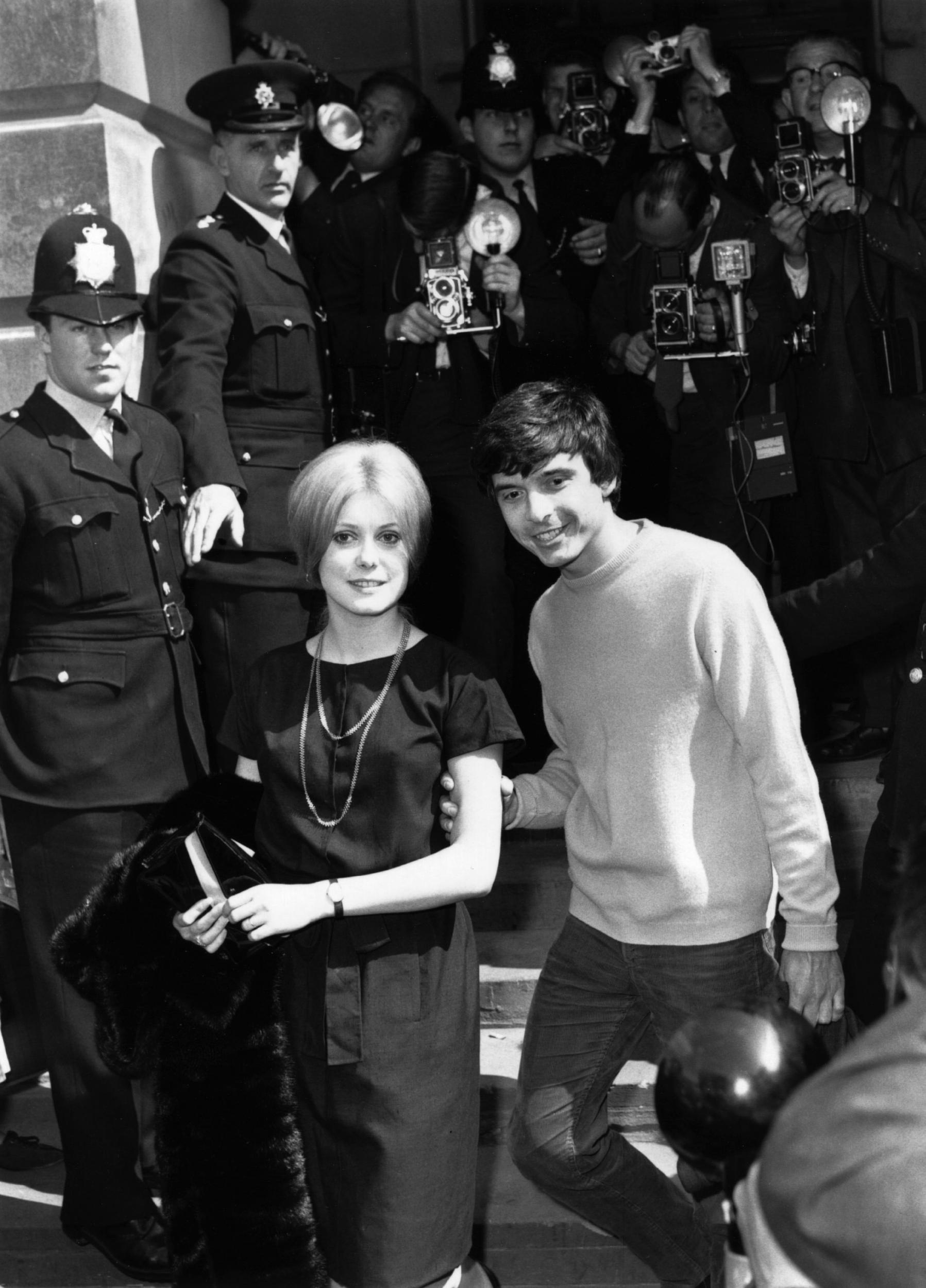 Deneuve and photographer David Bailey emerge from the registry office after their wedding in 1965