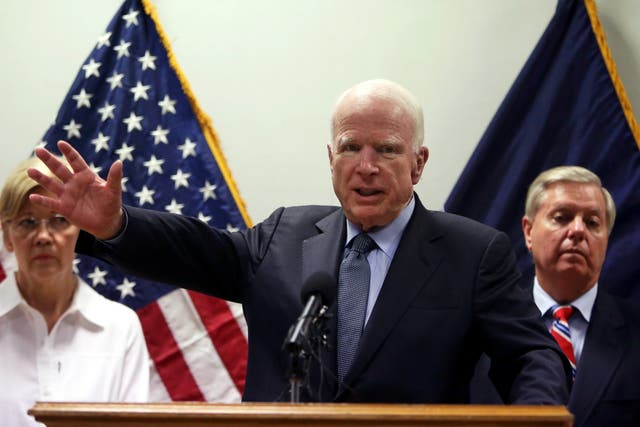 Senator John McCain, centre, speaks during a press conference in Kabul, with Senators Elizabeth Warren, left, and Lindsey Graham in the background