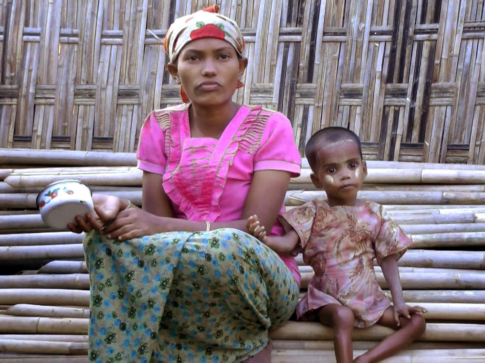 Rosmaida Bibi, who suffers from severe malnutrition, sits with her 20-year-old mother Hamida Begum outside their makeshift shelter at the Dar Paing camp north of Sittwe in Rakhine, Burma