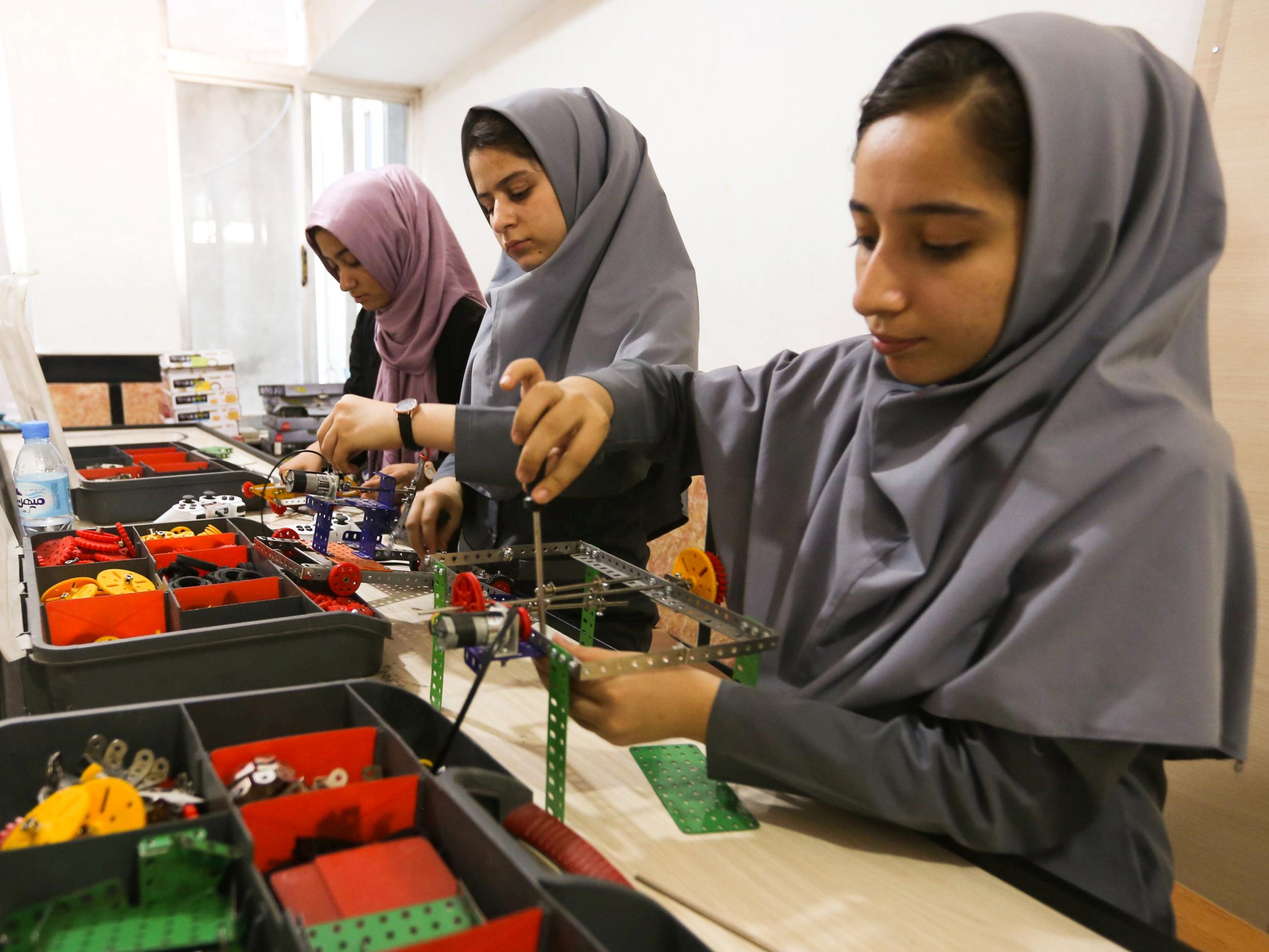 Members of Afghanistan's girls' robotics team work on their machines in Herat, Afghanistan