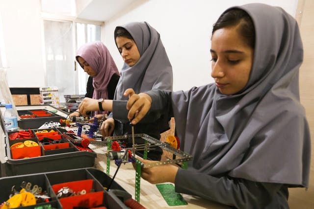 Members of Afghanistan's girls' robotics team work on their machines in Herat, Afghanistan