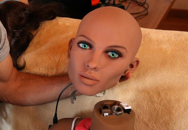 Catalan nanotechnology engineer Sergi Santos holds the head of Samantha, a sex doll packed with artificial intelligence providing her the capability to respond to different scenarios and verbal stimulus