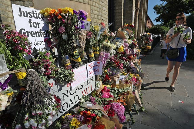 Flowers are left to commemorate the victims of the Grenfell Tower disaster