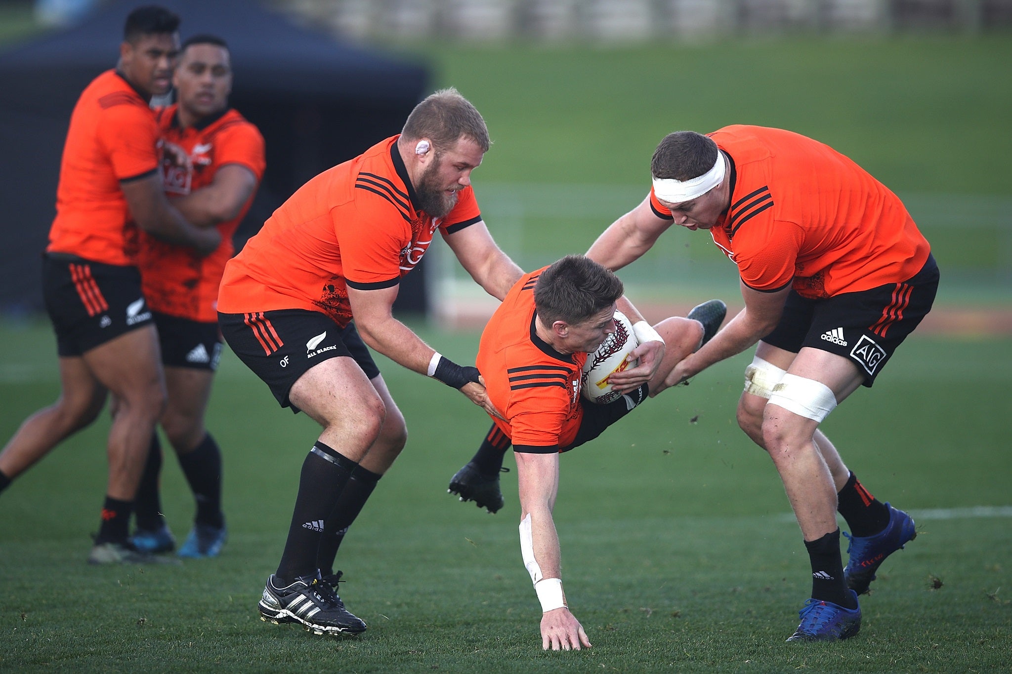 Beauden Barrett is upended by Owen Franks and Brodie Retallick in training