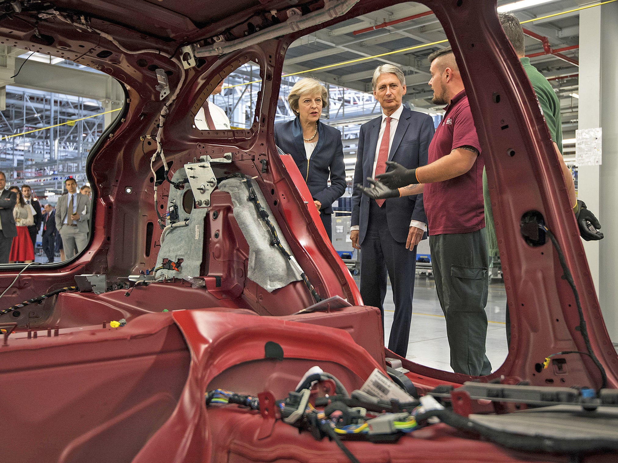 Theresa May and Philip Hammond view a car production line during a visit to the Jaguar Land Rover factory in Solihull