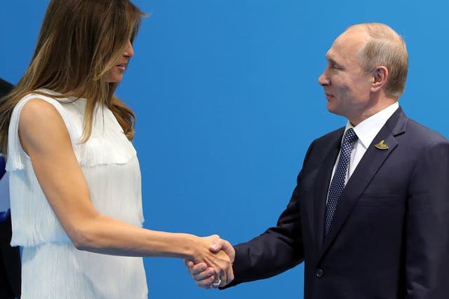 Russian President Vladimir Putin (R) and US First Lady Melania Trump (L) shake hands as they meet on the sidelines of the G20 summit in Hamburg, Germany, 07 July 2017.
