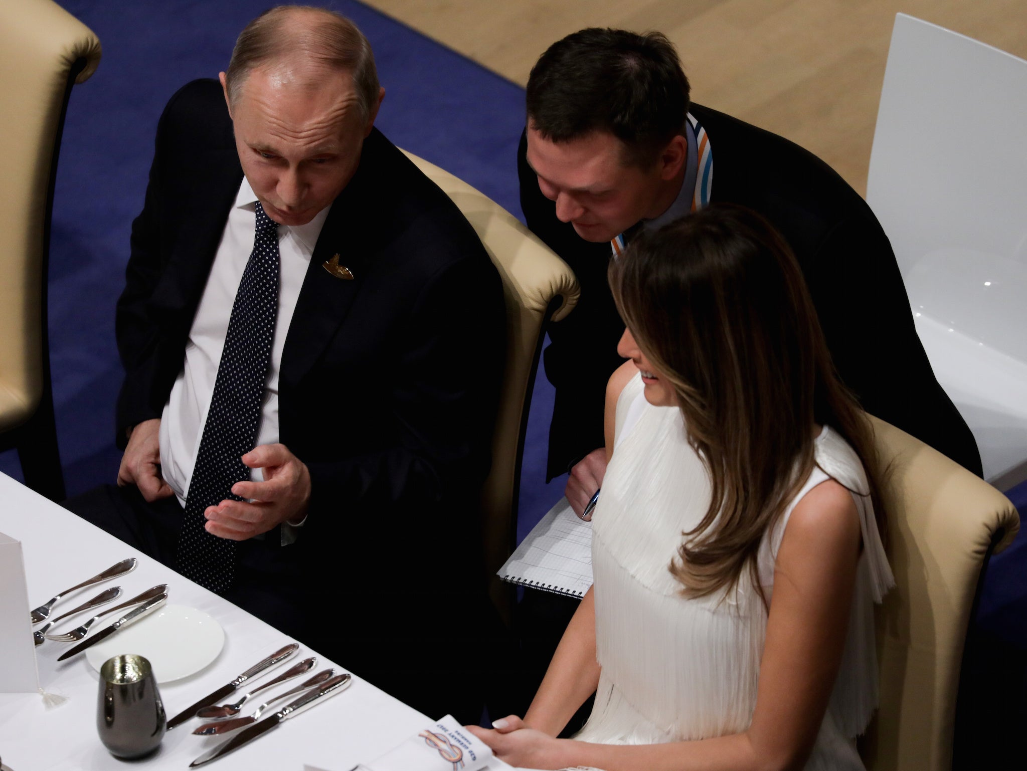 Russia's President Vladimir Putin laughs with Melania Trump during the official dinner at the Elbphilharmonie Concert Hall during the G20 summit in Hamburg