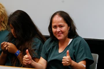 Isabel Martinez gestures towards news cameras during her first court appearance Lawrenceville