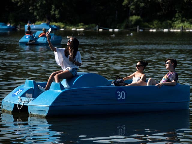 People enjoying themselves on the pedalos on the Serpentine lake in Hyde Park, London