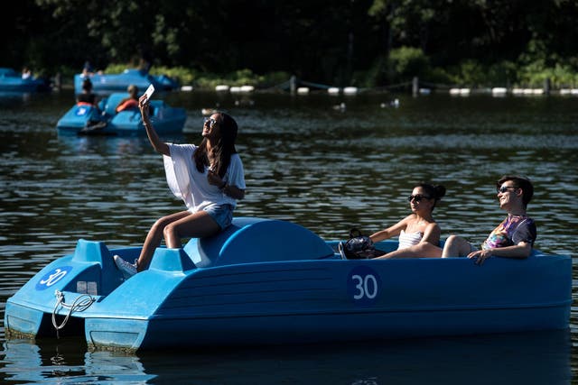 People enjoying themselves on the pedalos on the Serpentine lake in Hyde Park, London
