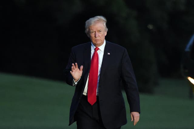 President Donald Trump waves as he returns to the White House