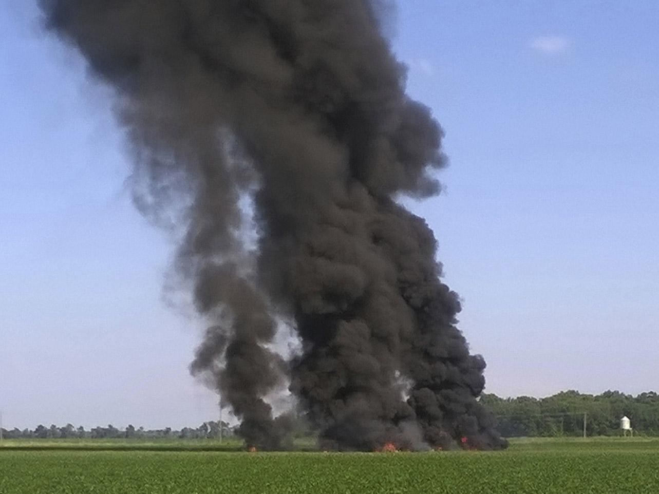 Smoke and flames rise into the air after a military transport airplane crashed in a field near Itta Bena, Mississippi, on the western edge of Leflore County killing several