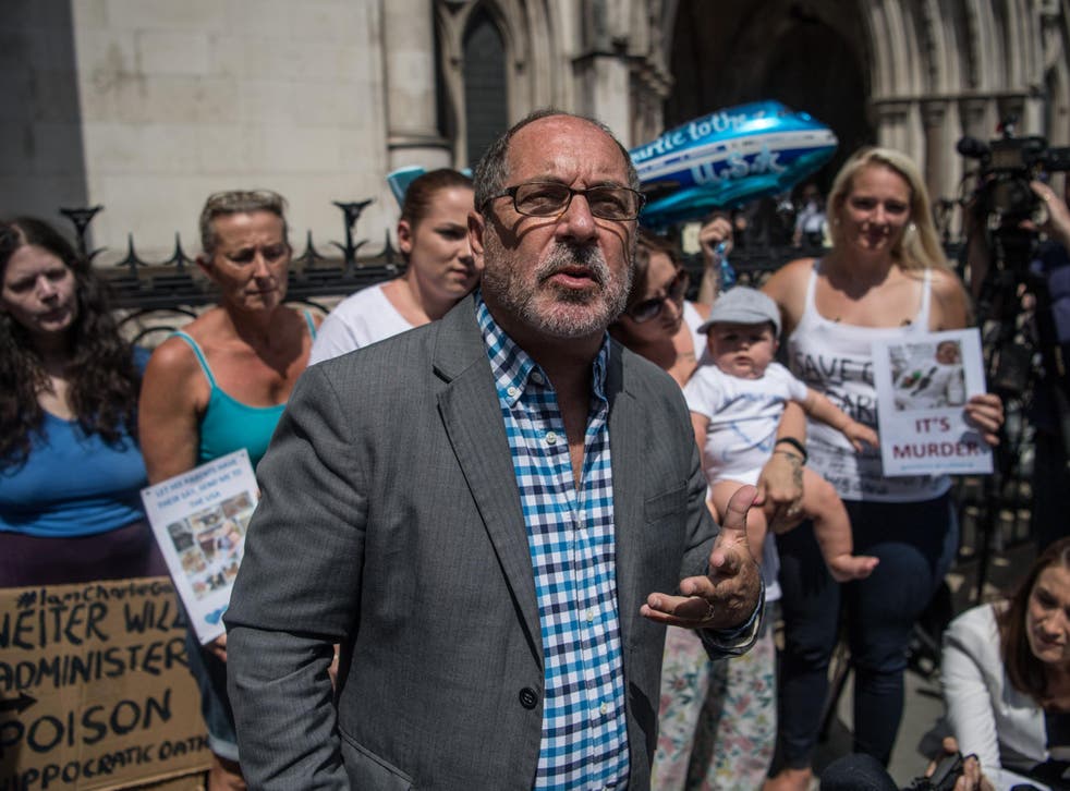 Supporters of Chris Gard and Connie Yates, the parents of terminally ill toddler Charlie Gard, look on as Reverend Patrick Mahoney speaks to the media outside the High Court