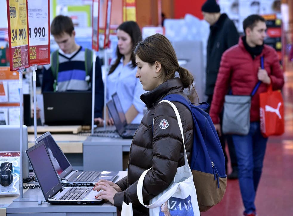 A woman looks at a laptop in a mall in central Moscow