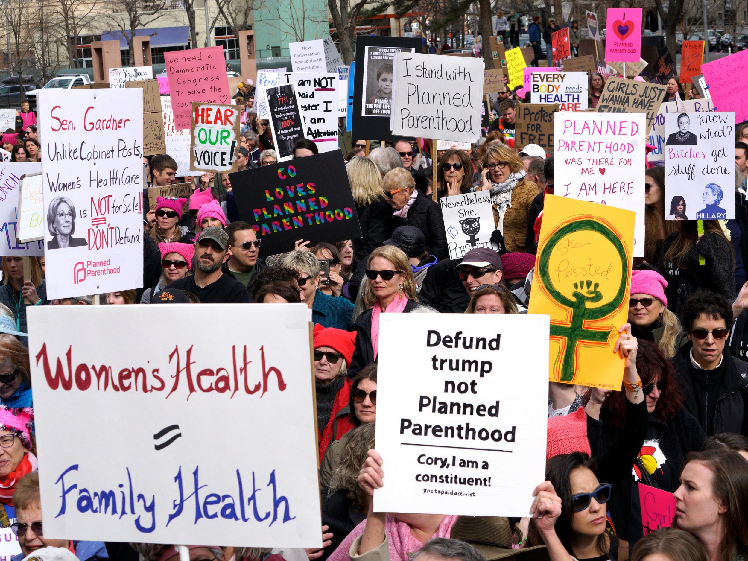 Planned Parenthood supporters hold signs at a protest in downtown Denver