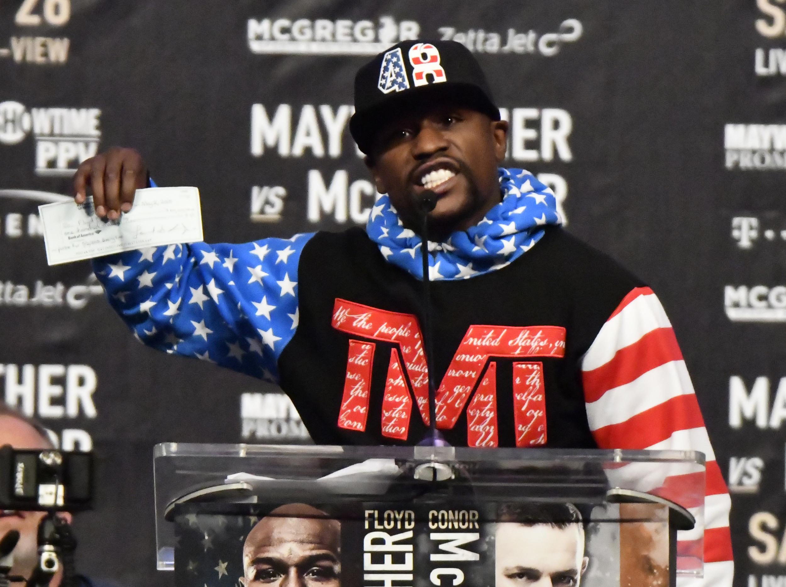 Mayweather with his cheque (Getty )