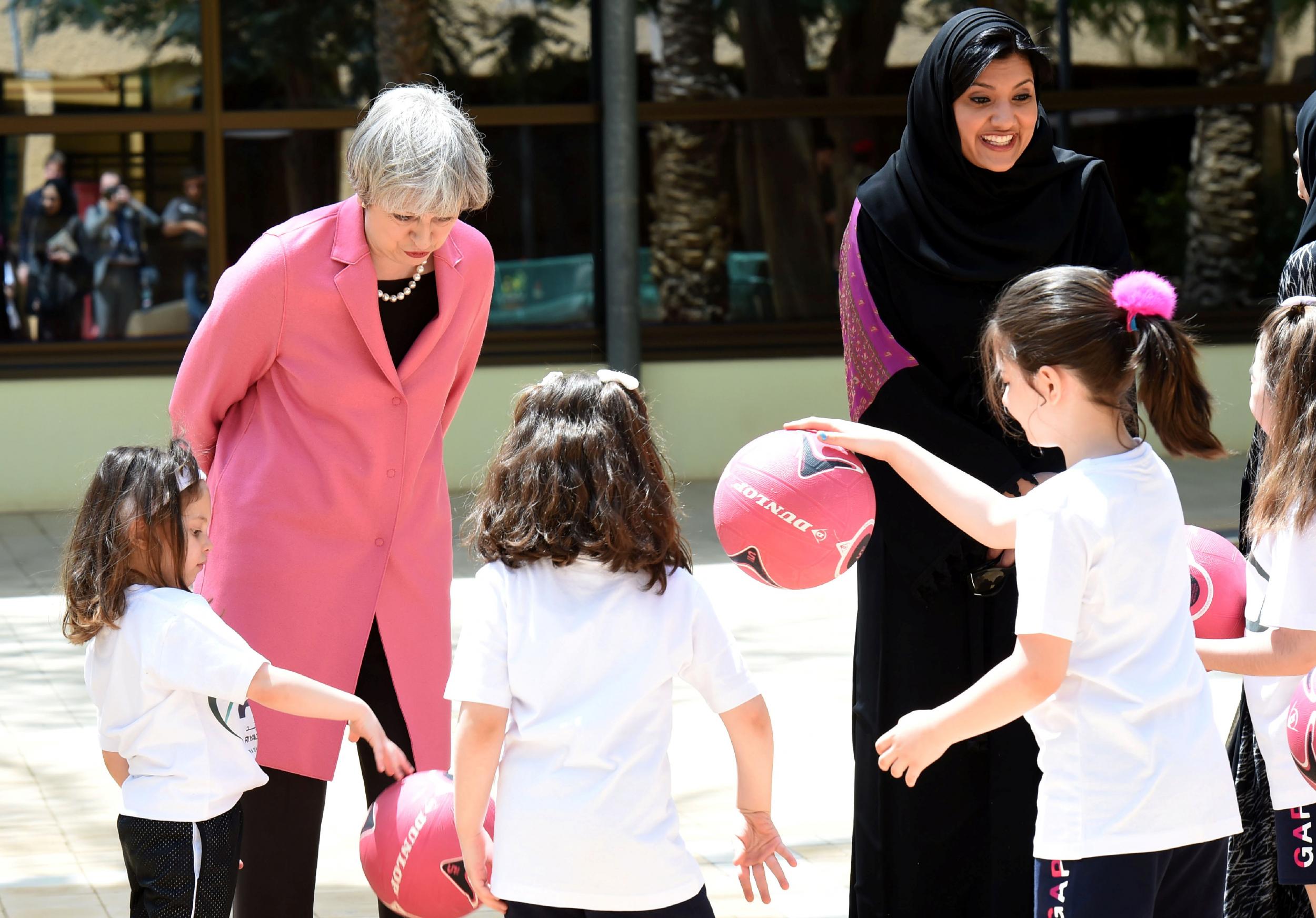 British Prime Minister Theresa May and the Saudi head of the women's section at the general authority for sports, Princess Reema Bint Bandar al-Saud, chat with Saudi girls during a basketball class in Riyadh on 5 April, 2017