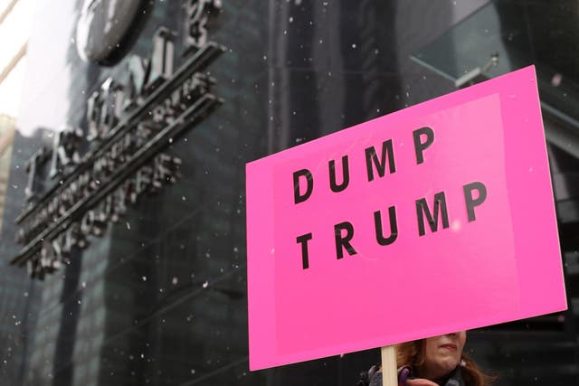 A protester holds a sign during the grand opening of the Trump International Hotel and Tower in Vancouver, Canada, on 28 February 2017
