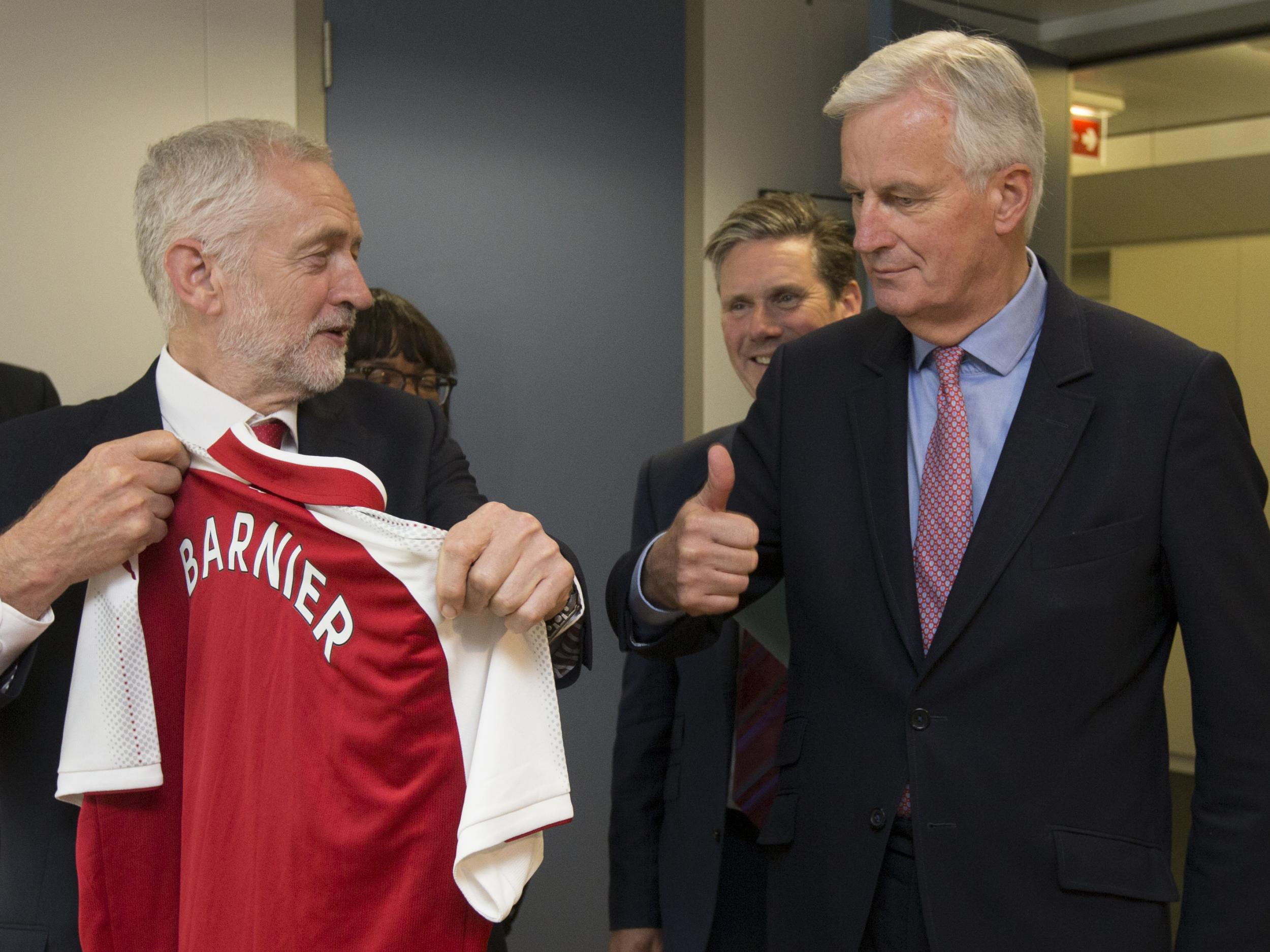 The EU chief Brexit negotiator Michel Barnier, right, receives an Arsenal football top from Labour Party leader Jeremy Corbyn prior to a meeting at EU headquarters in Brussels