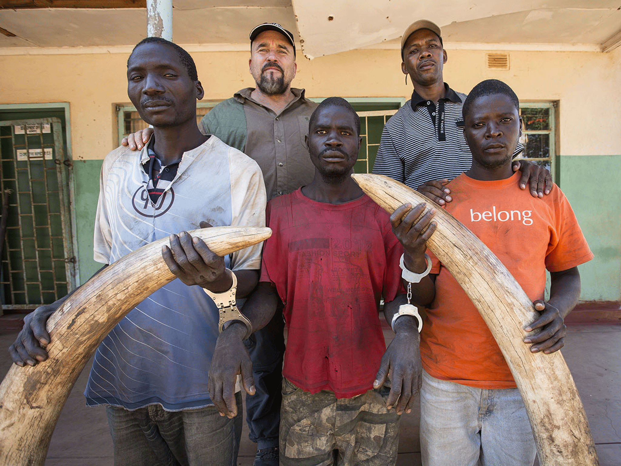 Gabriel Male, William Ngulube and Julias Kapomba pictured with the large ivory tusks they tried to sell to an undercover IFAW investigator. Behind them, to the left, is Mike Labuschagne, who heads the organisation's anti-poaching, criminal investigation and intelligence gathering activities, and another investigator.