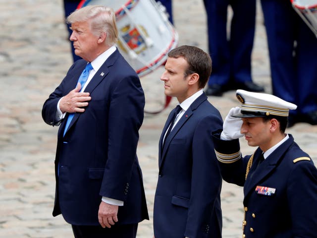 French President Emmanuel Macron and US President Donald Trump listen to national anthems during a welcoming ceremony at the Invalides in Paris