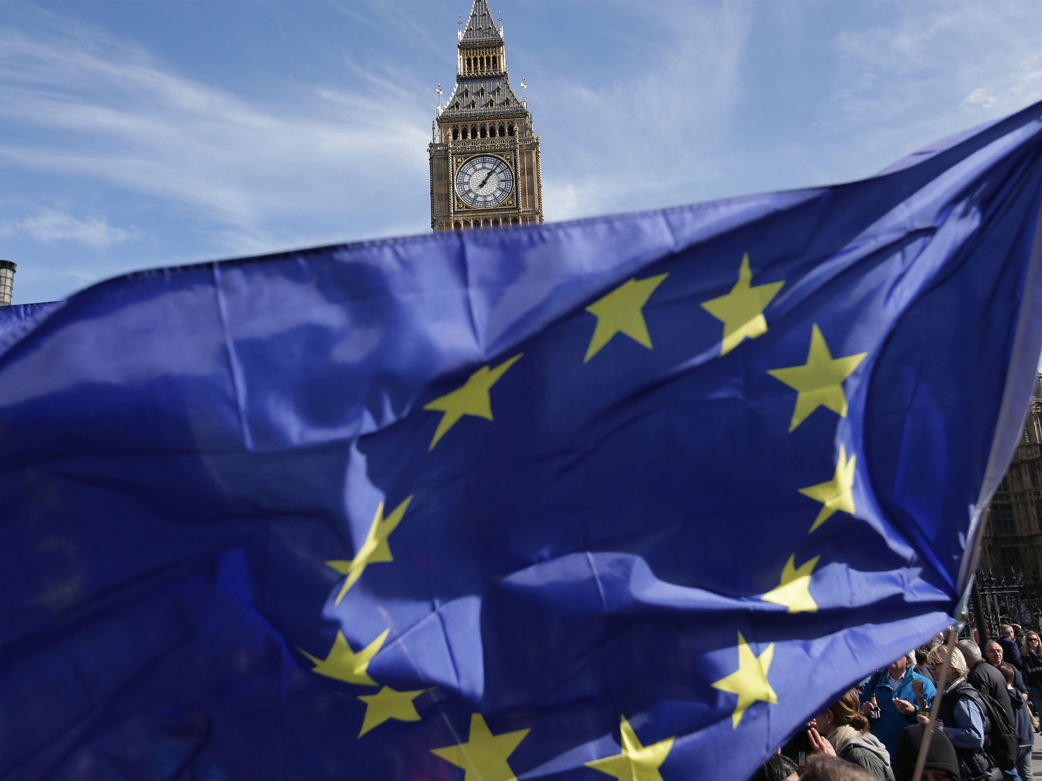 Demonstrators hold EU flags as they enter Parliament Square